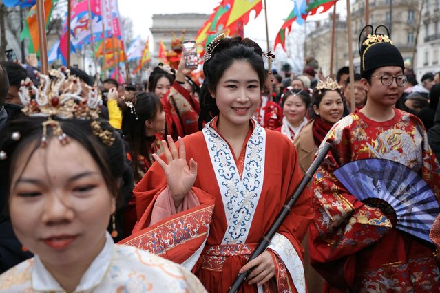 A member of the Chinese community takes part in a parade to celebrate the Chinese Lunar New Year on the Champs-Elysees in Paris on February 4, 2024. Chinese Lunar New Year starts on February 10, 2024 and will be the year of the Dragon. (Photo by Thomas Samson/AFP Photo)