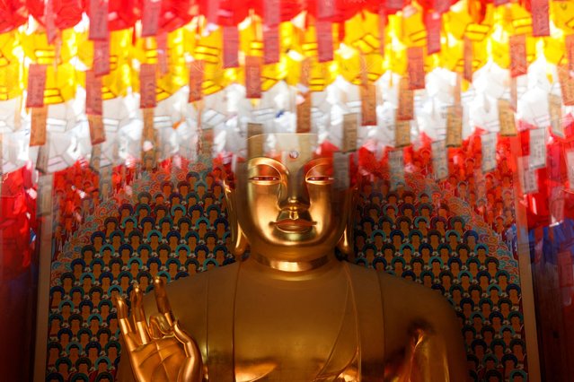 A statue of Buddha is overlapped with reflections of lotus lanterns with prayer petitions on a window, ahead of Vesak Day, the birthday of Buddha, at Jogyesa temple in Seoul, South Korea on April 24, 2025. (Photo by Kim Soo-hyeon/Reuters)