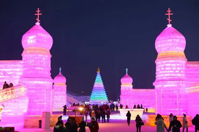 People visit the ice sculptures illuminated by coloured lights at Harbin ice and snow world for the 34th Harbin International Ice and Snow Festival in Harbin city, China's northern Heilongjiang province, January 4, 2018. (Photo by Wu Hong/EPA/EFE/Rex Features/Shutterstock)