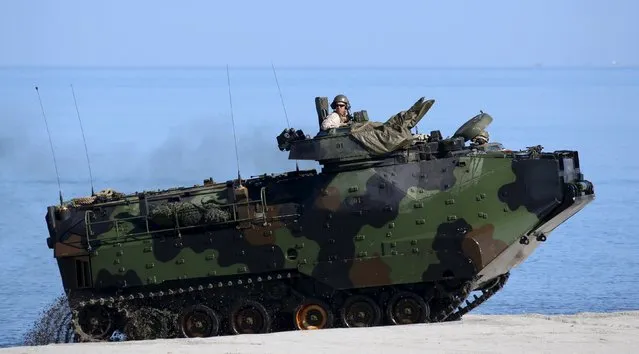 A U.S. soldier sits atop an amphibious armoured vehicle during assault exercises with Philippine marine troops in joint drills aimed at enhancing cooperation between the allies at a Philippine Naval base San Antonio, Zambales October 9, 2015. (Photo by Erik De Castro/Reuters)