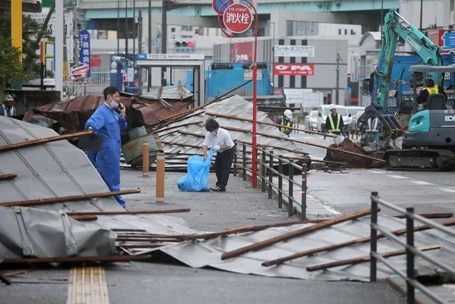 A clean-up crew works to remove roofs which were blown off into a street by strong winds brought by Typhoon Haishen in Fukuoka as the storm passes the southern Japanese island of Kyushu on September 7, 2020. Powerful Typhoon Haishen approached South Korea on September 7 after slamming southern Japan with record winds and heavy rains that prompted evacuation warnings for millions. (Photo by JIJI Press/AFP Photo)