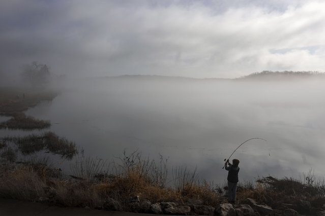 A boy fishes on a foggy lake Saturday, December 28, 2024, in Shawnee, Kan. (Photo by Charlie Riedel/AP Photo)