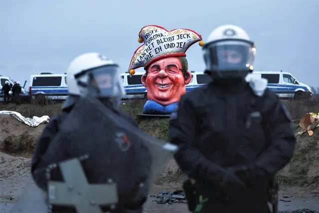 Police officers stand in front of a figure depicting North Rhine Westfalia's former Prime Minister Armin Laschet during a demonstration at Luetzerath, a village that is about to be demolished to allow for the expansion of the Garzweiler open-cast lignite mine of Germany's utility RWE, in Luetzerath, Germany on January 11, 2023. (Photo by Wolfgang Rattay/Reuters)