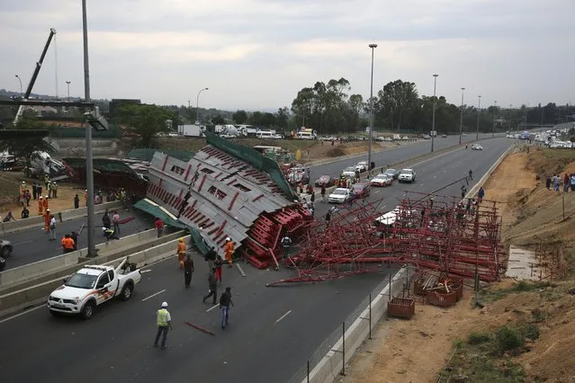 People look on after scaffolding for a bridge under construction collapsed on the M1 highway near a busy offramp leading to Sandton, South Africa October 14, 2015. (Photo by Siphiwe Sibeko/Reuters)