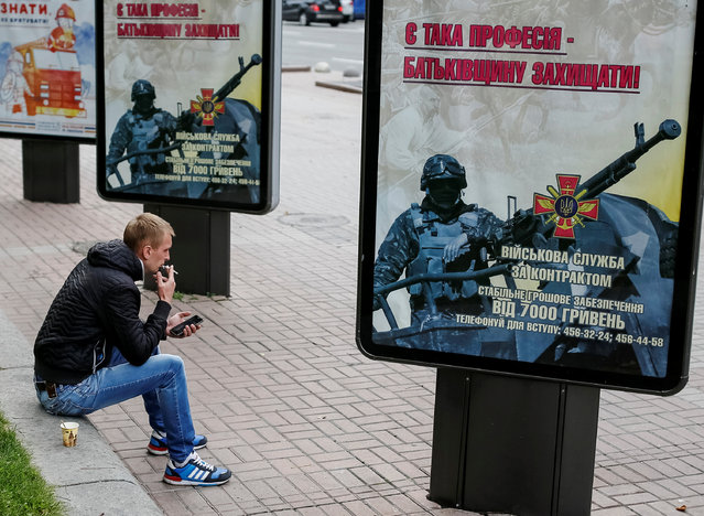 А man smokes near billboards promoting recruitment to the Ukrainian National Guard in Kiev, Ukraine September 23, 2016. (Photo by Gleb Garanich/Reuters)