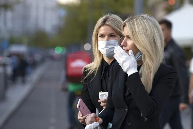 Two women wearing face masks against coronavirus as wait to cross the road in the center of in Moscow, Russia, Wednesday, September 23, 2020. Russia confirmed over six and half thousand new Covid-19 cases Wednesday, bringing the country's official number of cases to 1,122,241 as the number of new infections across the country continues to rise. (Photo by Alexander Zemlianichenko/AP Photo)