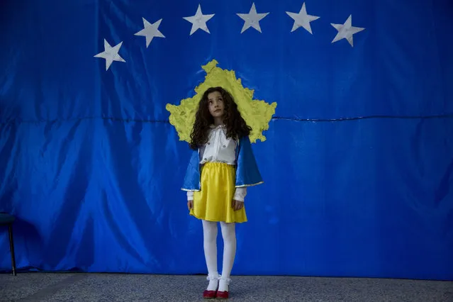 A student named Pavarsia Sopi, 10 poses for a photo in front of flag of Kosovo during an independence celebration ceremony at a school in the village of Sllovi near the town of Lipjan, Kosovo on Friday February 16, 2018, ahead of the upcoming 10th independence anniversary. A student of the school, Pavaresia Sopi, 10, was the first child born after Kosovo declared independence from Serbia in 2008. Pavaresia translates in English as “Independence”. (Photo by Visar Kryeziu/AP Photo)