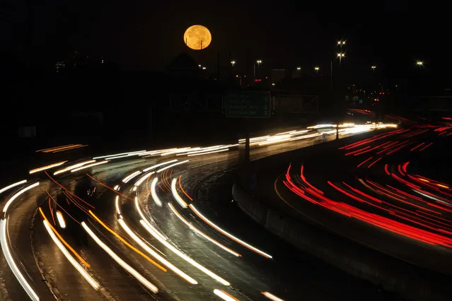 The full moon sets as morning traffic travels on a freeway Thursday, October 1, 2020, in Leawood, Kan. (Photo by Charlie Riedel/AP Photo)