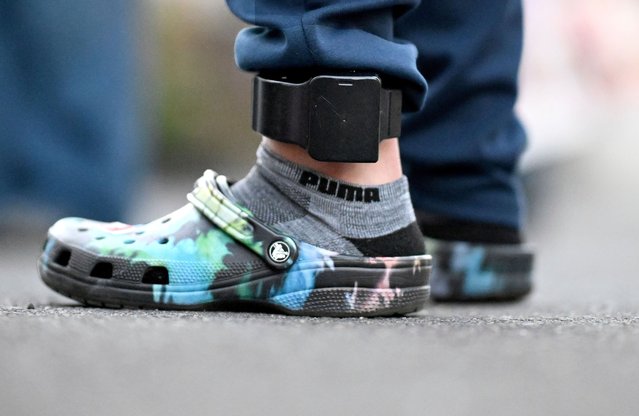 An undocumented gardener who was detained by Immigration and Customs Enforcement and later released from a processing facility in El Paso, Texas, after his wife paid a $5,000 bond, stands wearing an ankle monitor outside his home in California on July 30, 2025. (Photo by Will Lester/AP Photo)