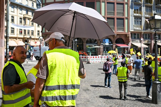 A man protects himself from the heat with an umbrella during a demonstration during a sweltering summer day on July 1, 2025 in Frankfurt, Germany. Weather forecasters are predicting record high temperatures for early July today and tomorrow as a heat wave sweeps the country. (Photo by Florian Wiegand/Getty Images)