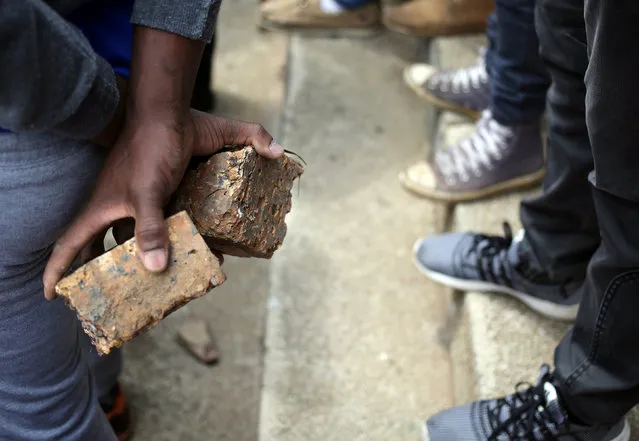 A student holds rocks during clashes with the South African police at Johannesburg's University of the Witwatersrand, South Africa, October 4, 2016. (Photo by Siphiwe Sibeko/Reuters)
