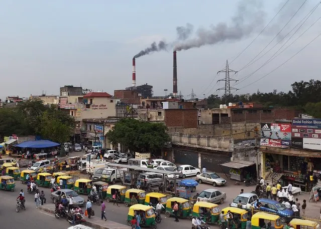In this photograph taken on April 6, 2015, smoke billows from two smoke stacks at the coal-based Badarpur Thermal Station in New Delhi. India, the world's third biggest carbon emitter, is set to ratify the Paris agreement on climate change October 2, 2016, on the birthday of the country's famously ascetic independence leader Mahatma Gandhi. (Photo by Money Sharma/AFP Photo)