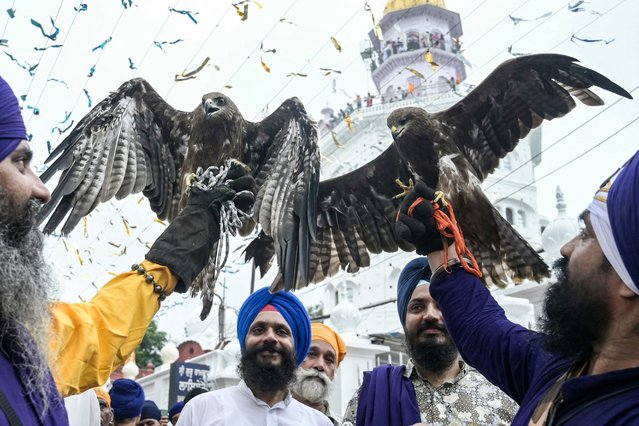 Sikh devotees carry their pet eagles during a religious procession from the Gurudwara Ramsar to the Akal Takht Sahib to mark the anniversary of the installation of the sacred book at the Golden Temple in Amritsar on August 24, 2025. (Photo by Narinder Nanu/AFP Photo)