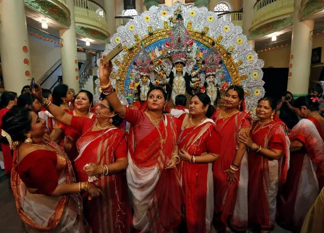 Hindu women use their mobile phones to take pictures after worshipping the idol of the Hindu goddess Durga on the last day of the Durga Puja festival in Kolkata, India October 11, 2016. (Photo by Rupak De Chowdhuri/Reuters)