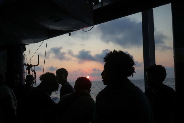 Rescued migrants look at a sunset aboard a migrant search-and-rescue ship operated by German NGO Sea-Watch as the ship makes its way toward Salerno, Italy, on Tuesday, August 12, 2025. (Photo by Louisa Gouliamaki/Reuters)