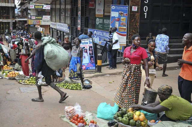 Street traders sell mangos and other fruit before being told by security forces to pack up and leave, on a street in Kampala, Uganda Thursday, November 19, 2020. (Photo by AP Photo/Stringer)