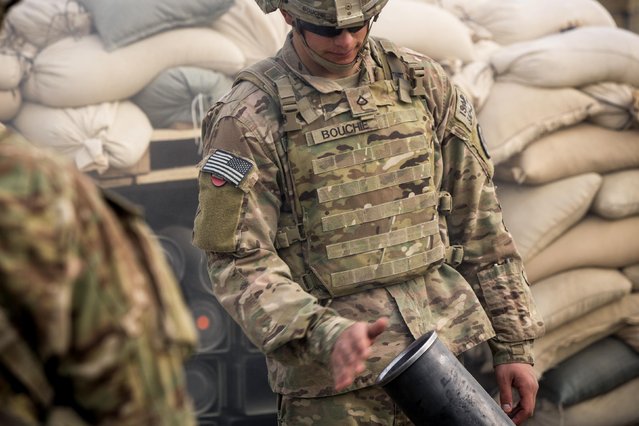 A U.S. soldier from the 3rd Cavalry Regiment waves the smoke from the opening of a mortar during an exercise on forward operating base Gamberi in the Laghman province of Afghanistan December 24, 2014. (Photo by Lucas Jackson/Reuters)