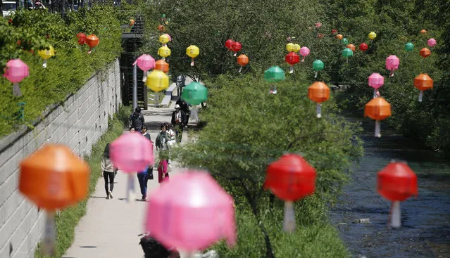 Visitors walk through a stream near the lanterns hanging to celebrate Buddha's upcoming birthday on May 14, in the Buddhist Era 2560, in Seoul, South Korea, Friday, May 13, 2016. Many Buddhists will temples across the nation to celebrate the birthday and pray with their wishes. (Photo by Lee Jin-man/AP Photo)