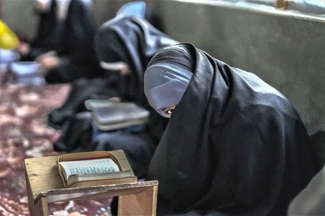 A Kashmiri Muslim girl reacts to camera as she attends recitation classes of the holy Quran during the fasting month of Ramadan in Srinagar, Indian controlled Kashmir, Sunday, March 26, 2023. Muslims across the world are observing the holy fasting month of Ramadan, where they refrain from eating, drinking and smoking from dawn to dusk. (Photo by Mukhtar Khan/AP Photo)