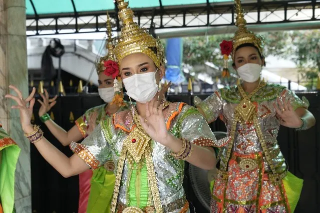 Thai classical dancers wearing face masks to help protect themselves from the coronavirus perform at the Erawan Shrine in Bangkok, Thailand, Monday, February 7, 2022. (Photo by Sakchai Lalit/AP Photo)