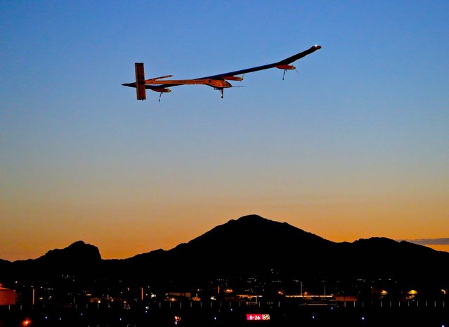 Solar Impulse, piloted by Andr' Borschberg, takes flight during the second leg of the 2013 Across America mission, at dawn from Sky Harbor International Airport in Phoenix, on May 22, 2013. The solar powered aircraft is scheduled to land at Dallas/Fort Worth International Airport on Thursday. The plane's creators, Bertrand Piccard and Borschberg, said the trip is the first attempt by a solar airplane capable of flying day and night without fuel to fly across America. (Photo by Matt York/Associated Press)