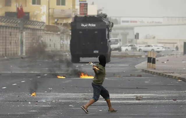 A protester throws a Molotov cocktail at a riot police armoured personnel carrier, at a highway in the village of Sitra, south of Manama, January 9, 2015. Several demonstrations calling for the release of Sheikh Ali Salman, head of the al-Wefaq Islamic Society, and resulting in clashes with riot police, were held across the country, local media reported. Ali Salman was arrested on December 28, 2014.(Photo by Hamad I. Mohammed/Reuters)
