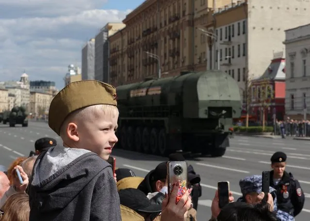 Spectators watch Russian military vehicles driving along a street after a parade on Victory Day, which marks the 78th anniversary of the victory over Nazi Germany in World War Two, in Moscow, Russia on May 9, 2023. (Photo by Yulia Morozova/Reuters)