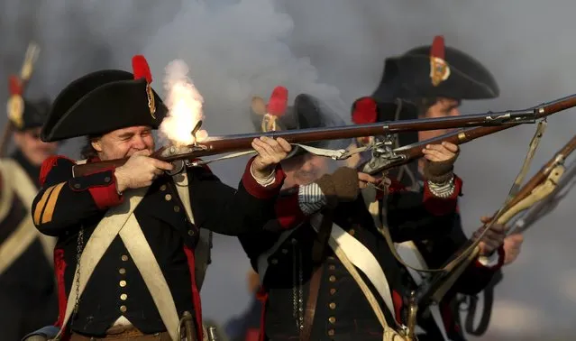 A history enthusiast, dressed as a soldier, fires a fake rifle during the re-enactment of Napoleon's famous battle of Austerlitz near the southern Moravian town of Slavkov u Brna December 5, 2015. (Photo by David W. Cerny/Reuters)