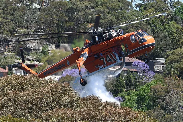 A bushfire in the Sydney suburb of Castle Cove has water dumped on it by a firefighting helicopter in Australia's largest city, November  5, 2016. (Photo by Dan Himbrechts/Reuters/AAP)
