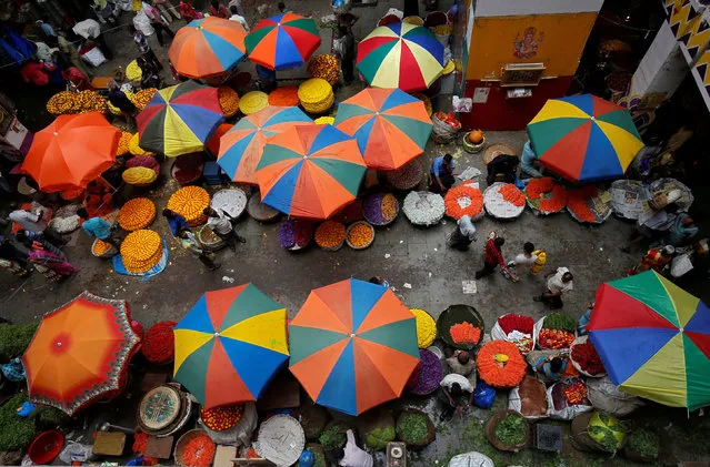 Vendors sit under umbrellas inside a wholesale flower market in Bengaluru, India, April 12, 2018. (Photo by Abhishek N. Chinnappa/Reuters)