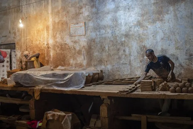 Potters work at a ceramics factory in Rabat, Morocco, 24 May 2023. The pottery craft in Morocco is resisting in order to withstand the transformations taking place in the country's traditional industry sector. Despite the local and international demand for tagines, water jugs, cups, and other ceramic products, the low demand of young people to work in these crafts threatens them with a significant decline. (Photo by Jalal Morchidi/EPA)