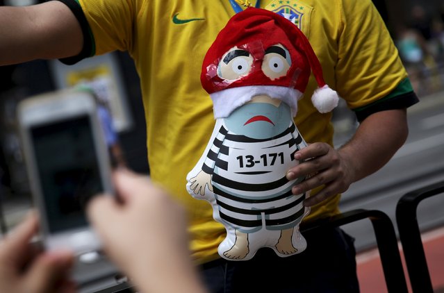 A man holds an inflatable doll known as “Pixuleco” of Brazil's former president Luiz Inacio Lula da Silva with a Christmas hat during a protest calling for the impeachment of Brazil's President Dilma Rousseff in Sao Paulo, Brazil, December 13, 2015. (Photo by Nacho Doce/Reuters)
