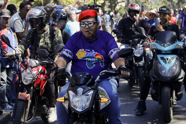 Government supporters ride past opponents of Venezuelan President Nicolas Maduro protesting a day before he will be sworn-in for a third six-year term despite credible evidence that he lost the presidential election, in Caracas, Venezuela, January 9, 2025. (Photo by Cristian Hernandez/AP Photo)