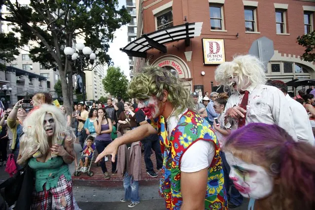 People dressed up as zombies take part in a zombie walk in the Gaslamp Quarter during the Comic Con International convention in San Diego, California July 13, 2012. (Photo by Mario Anzuoni/Reuters)