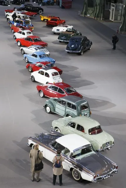 Visitors walk past vintage and classic cars displayed by Bonhams auction house, during an exhibition, at the Grand Palais in Paris, Wednesday, February 4, 2015. (Photo by Jacques Brinon/AP Photo)