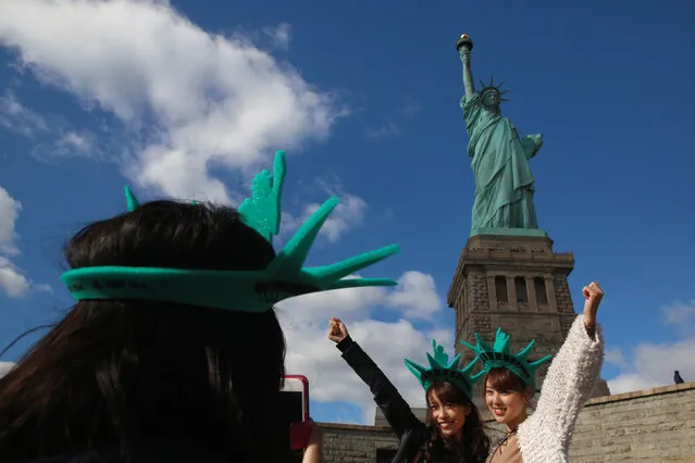 Japanese tourists pose in front of the Statue of Liberty on the 130th anniversary of the dedication in New York Harbor, in New York City, U.S., October 28, 2016. (Photo by Brendan McDermid/Reuters)