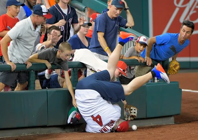 A spectator falls onto the field while attempting to retrieve a foul ball during Major League Baseball’s Home Run Derby at Nationals Park in Washington on July 16, 2018. (Photo by John McDonnell/The Washington Post)