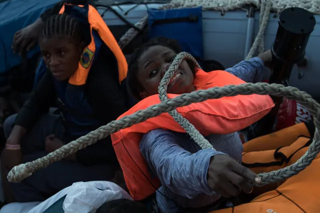 Refugees try to scramble from a rescue craft as members of MOAS, Migrant Offshore Aid Station make resues on November 22, 2016 in Pozzollo Italy. The MOAS team worked through the night and into the next morning rescuing “approximately” 600 people from vessels. MOAS are currently patrolling international waters off the coast of Libya, and running rescue missions for the many migrants and refugees who continue to attempt to make the dangerous crossing across the Mediterranean Sea to Italy. MOAS are a Malta based registered foundation dedicated to providing professional search-and-rescue assistance to refugees and migrants in distress at sea and work alongside with the Red Cross on board the Topaz Responder. The number of deaths this year of people crossing the Mediterranean has risen to almost 4,300. MOAS alone have rescued around 19,000. (Photo by Dan Kitwood/Getty Images)