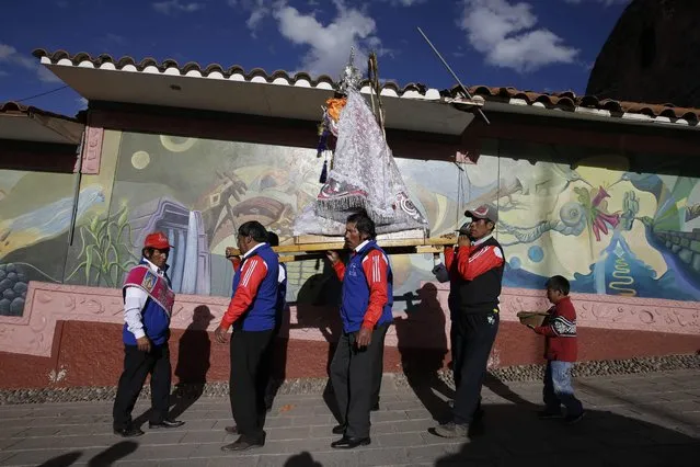 In this Sunday, August 5, 2018 photo, “cargadores” or male carriers walk with a statue of Our Lady of Copacabana belonging to resident Libia Espinoza, in a religious procession honoring the Bolivian virgin, in Cuzco, Peru. Unlike many of the regional feast day celebrations dating back hundreds of years, this one, initiated by Espinoza, is marking its tenth year. (Photo by Martin Mejia/AP Photo)