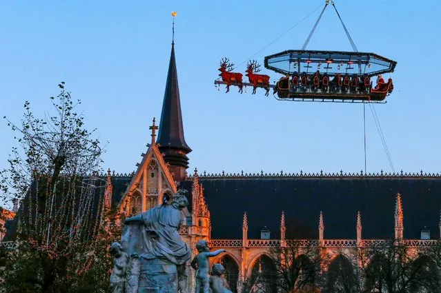 Guests enjoy dinner at the table “Santa in the sky”, lifted by a crane and decorated to match the appearance of a “Santa Sleigh” as part as the Christmas festivities, in Brussels, Belgium, November 25, 2016. (Photo by Yves Herman/Reuters)