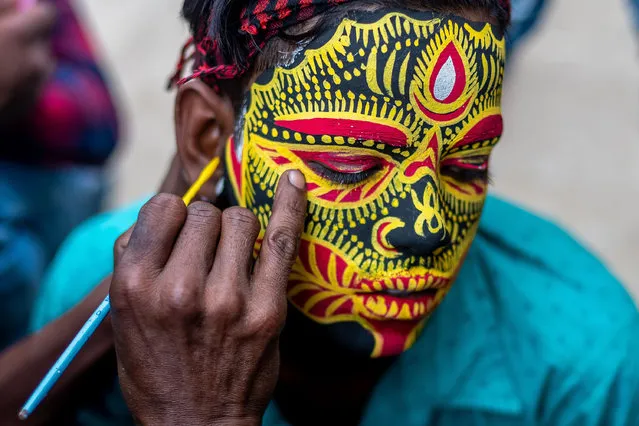 Hindu boy face is painted colourfully by an artist as they attend and celebrate Bengali New Year festival called Gajan in West Bengal state of India on April 11, 2021. Gajan associated with gods as Shiva, Neel and Dharmathakur. this festival spans around a week time, starting from the last week of Choitro continuing till the end of the Bengali New Year. Participants of this festival are known as Sannyasi or Bhokta. The central theme of this festival is to derive satisfaction through non-sexual pain, devotion and sacrifice. (Photo by Saurabh Sirohiya/Pacific Press/Rex Features/Shutterstock)