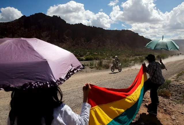 Robert Van Pelt of the Netherlands rides his Husqvarna as two women cheer while holding a Bolivian national flag during the fifth stage Jujuy-Uyuni in the Dakar Rally 2016 near Uyuni, Bolivia, January 7, 2016. (Photo by Marcos Brindicci/Reuters)