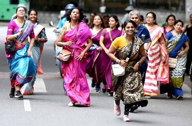 Indian women wearing sarees participate in “Saree Run” in Bangalore, India, 27 August 2023. Hundreds of women took part in a saree run and walk to help women embrace fitness in any outfit they are comfortable in to promote both tradition and fitness among women. (Photo by Jagadeesh N.V./EPA/EFE)