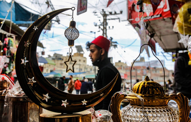 A Palestinian shopkeepers displays lanterns and other decorative items ahead of the fasting month of Ramadan, in the town of Khan Yunis in the southern Gaza Strip, on April 11, 2021, amid the coronavirus pandemic. Throughout the Muslim holy month of Ramadan, devout Muslims abstain from food and drink from dawn until sunset. (Photo by Said Khatib/AFP Photo)