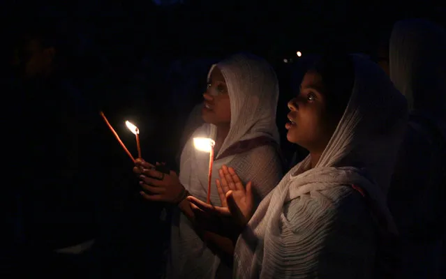 Ethiopian Orthodox faithful hold candles as they attend the eve-prayers during the Timket celebration to commemorate the baptism of Jesus Christ by John the Baptist in the River Jordan, in Gondar, Ethiopia, January 19 2016. (Photo by Tiksa Negeri/Reuters)
