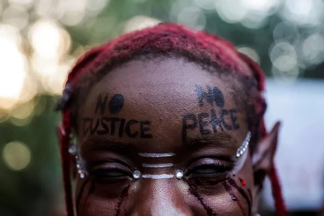 A demonstrator shows a message written on the forehead during a demonstration on the first anniversary of the death of George Floyd, in the Brooklyn borough of New York City, New York, U.S., May 25, 2021. (Photo by Jeenah Moon/Reuters)