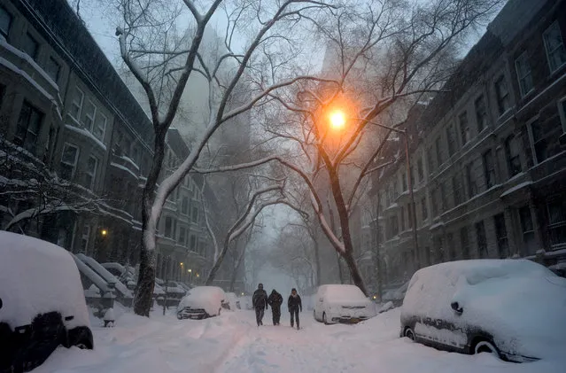 Pedestrians walk in New York, Saturday, January 23, 2016. A massive winter storm buried much of the U.S. East Coast in a foot or more of snow by Saturday, shutting down transit in major cities, stranding drivers on snowbound highways, knocking out power to tens of thousands of people. (Photo by Craig Ruttle/AP Photo)