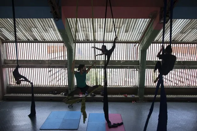 Members of the Multidisciplinary Circus Nuevo Karakara practice aerial acrobatics after the COVID-19 lockdown was eased in Caracas, Venezuela, Tuesday, April 27, 2021. (Photo by Ariana Cubillos/AP Photo)