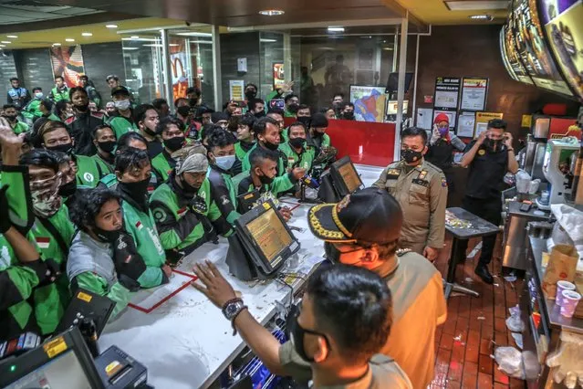 Food delivery riders queue up at a McDonald’s outlet in Bogor on June 9, 2021, to buy the new BTS-meal deal for hungry fans in the K-Pop mad country, causing more than a dozen McDonald's outlets to temporarily shuttered over virus fears. (Photo by Aditya Aji/AFP Photo)