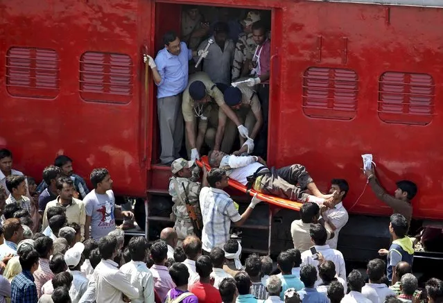 An injured passenger is being taken on a stretcher after a train accident at Rae Bareli district in the northern Indian state of Uttar Pradesh March 20, 2015. At least 30 people were killed and 50 injured when an express train overshot a railway signal and some carriages went off the rails in a northern Indian state on Friday, officials said. (Photo by Reuters/Stringer)